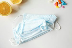 Medizinische Masken und Vitamine auf einem Tisch als Symbole für Immunschutz. Schlafmangel und schwaches Immunsystem erhöhen die Anfälligkeit für Infektionen.