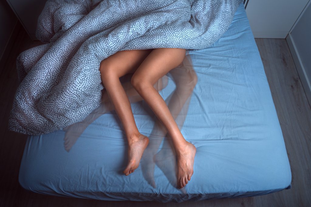 Bewegung der Beine im Bett, ein häufiges Symptom des Restless-Legs-Syndroms.