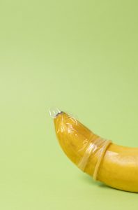 Eine Banane mit einem Kondom symbolisiert die Problematik von Impotenz und erektiler Dysfunktion. Schlafapnoe kann die Testosteronproduktion senken und zu Potenzproblemen führen, doch eine gezielte Behandlung kann helfen, die Schlafqualität und sexuelle Gesundheit zu verbessern.